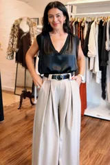Blusa sin mangas de satén negro con escote en V profundo y terminaciones en contraste. Presenta un diseño fluido y elegante con corte recto.