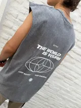 Musculosa sin mangas color gris oscuro con efecto acid wash. Presenta un pequeño estampado blanco en el pecho con un gráfico de globo terráqueo estilizado y una flor de asterisco.