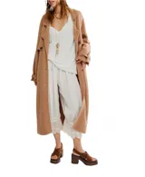 Tapado largo de lana color tostado con diseño tipo trench. Presenta solapas anchas, cierre frontal con botones, bolsillos laterales y detalle de trabas con botones en los puños.