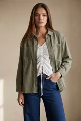 Sobrecamisa de algodón peinado en color verde oliva, con corte oversize, cuello camisero, cierre frontal con botones metálicos y bolsillos frontales tipo parche.