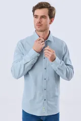 Camisa de manga larga confeccionada en mezcla de lino y algodón, con diseño de rayas finas, cuello camisero y cierre frontal de botones.