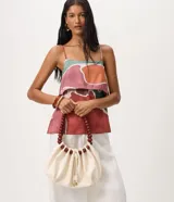 Cartera hobo marca Satinato en poliuretano color marfil, con diseño fruncido, cierre de cordón ajustable y asa rígida de esferas de madera.