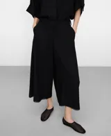 Pantalón culotte negro de lino y viscosa, con trabillas en la cintura, bolsillos laterales, bolsillos de plastrón en la espalda y bajo desflecado.