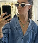 Collar de cuentas de vidrio verdes con detalles de perlas blancas y un dije central en forma de estrella de mar verde con puntos blancos. Incluye una cadena de extensión para ajustar el largo.