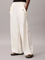 Pantalón cargo de corte relajado confeccionado en una mezcla de lino y algodón. Presenta cintura elástica, bolsillos laterales amplios con solapa y diseño de pierna ancha.