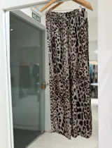 Pantalón wide leg de tiro alto con estampa animal print de leopardo, cintura elástica fruncida y diseño fluido.