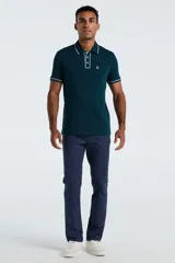Polo de manga corta color verde oscuro, con cuello y puños acanalados con detalle de líneas blancas. Presenta cierre frontal de tres botones y un bolsillo en el pecho con el logo de la marca bordado.