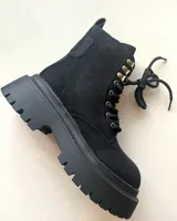 Borcego negro de caña media con cordones y suela track.