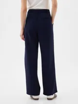 Pantalón de vestir negro de corte recto y tiro alto, con pinzas frontales y bolsillos laterales.