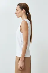 Musculosa de algodón color rojo, con cuello redondo, corte sin mangas y detalle de botones decorativos en los hombros.