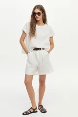 Blusa de lino color blanco, con cuello bote y mangas cortas de corte holgado.