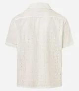Camisa de hombre de calce holgado (comfort), confeccionada en algodón con técnica laise que incluye perforaciones florales cortadas con láser. Cuenta con cuello tipo solapa, manga corta y cierre frontal con botones al tono.