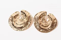 Par de aros dorados con forma de ostra y textura irregular.