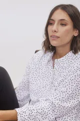 Blusa tipo camisa blanca de manga larga con botones nacarados ocultos con cartera. Tela suave y sedosa con doble capa en el frente para evitar transparencias.