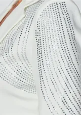 Blazer corto de corte estructurado en color blanco, con solapas clásicas y cierre frontal de un botón. Presenta un diseño decorativo con aplicaciones de pedrería brillante que recorren los hombros y las mangas en patrones curvos y geométricos.
