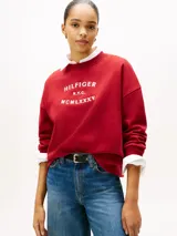 Buzo de cuello redondo confeccionado en tejido de felpa, con diseño de corte holgado y mangas largas. Presenta un estampado frontal con la inscripción HILFIGER N.Y.C. MCMLXXXV en color blanco.