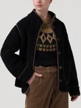 Chaqueta polar acolchada color azul marino, con diseño de rombos y ribetes en contraste color marrón. Presenta cuello alto, cierre frontal con botones y bolsillos frontales estructurados.