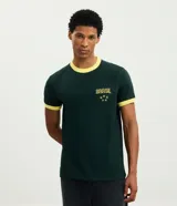 Remera de algodón color verde oscuro con cuello redondo y bordes de mangas en color amarillo. Presenta un bordado frontal con la palabra Brasil y estrellas en color amarillo.
