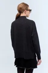 Polera tejida de punto confeccionada en lambswool color gris claro, con cuello alto y calce holgado.