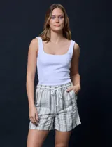 Short color crema con finas rayas verticales grises, pretina elastizada con cordón de ajuste, bolsillos delanteros y traseros.