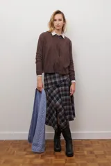 Falda midi de corte irregular con diseño a cuadros en tonos marrones, negros y beige. Presenta una silueta acampanada con caída fluida.