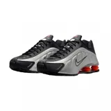 Championes Nike Shox R4 color negro, con diseño clásico de columnas amortiguadoras en el talón y capellada de material sintético con detalles perforados.