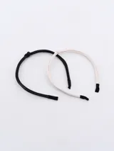 Set de dos tiaras para el pelo, una negra y otra blanca, forradas en cuero sintético.