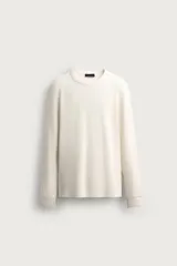Remera de manga larga de corte relajado, confeccionada en tejido de algodón con textura waffle en color crudo. Presenta cuello redondo y puños en rib.