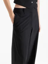 Pantalón de vestir tiro alto color celeste, de corte wide leg y largo hasta el suelo, con bolsillos delanteros decorados con volados tableados y bolsillos ojal en la espalda.