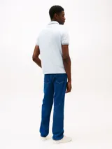 Chomba celeste de algodón elástico con cuello y mangas ribeteados en azul marino y rojo. Corte slim fit y logo de Tommy Hilfiger bordado en el pecho.