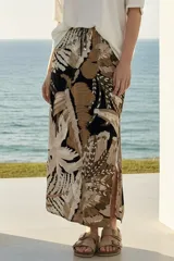 Falda larga con estampado de hojas en tonos beige, marrón y negro, con cintura elastizada y cordón ajustable.