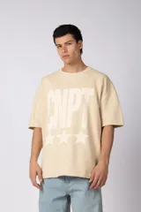 Remeron de corte oversize color beige, con estampado frontal en color blanco que incluye tipografía y estrellas con efecto desgastado.