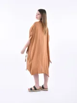 Vestido de tela fluida color marrón medio, con escote en V y mangas cortas tipo kimono. El ruedo es asimétrico con aberturas laterales.