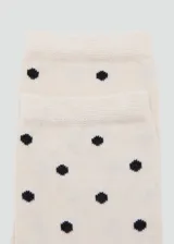 Medias de punto color crudo con estampado de lunares negros.