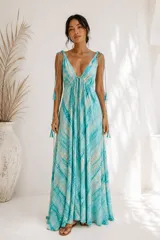 Vestido largo turquesa con estampado tie-dye, escote en V profundo, tirantes finos regulables con borlas y diseño amplio de gran caída.