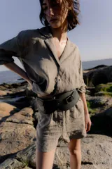 Faja ancha de cuero sintético negro con hebilla dorada y bolsillo lateral.