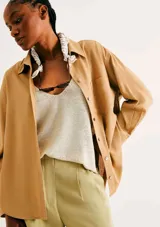 Camisa de manga larga con diseño extragrande y oversize, de color mostaza, con cuello clásico, cierre frontal con botones y bolsillo aplicado en el pecho.