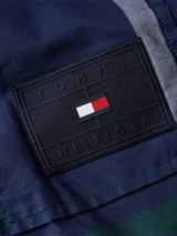 Sobrecamisa de hombre Tommy Hilfiger de corte informal, confeccionada en algodón Oxford con estampado de cuadros en tonos azul, verde, amarillo y blanco. Cuenta con cuello inglés, bolsillo de parche en el pecho con logo de la marca, puños redondeados con dos botones y detalles distintivos de Tommy Hilfiger.