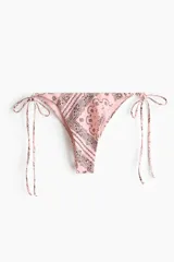 Vedetina de bikini rosa con estampado paisley en tonos negros y blancos, tiro medio y tiras ajustables para atar en los laterales.