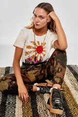 Pantalón tipo babucha con estampado de piel de serpiente en tonos marrones y naranjas, con cintura elástica negra.