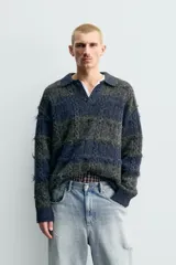 Polo de punto con textura, diseño de rayas horizontales en tonos gris y azul, cuello solapa con cierre frontal de botones y mangas largas con terminaciones en rib.