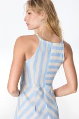 Vestido midi de lino a rayas verticales color verde y blanco, con cuello halter y corte evasé.