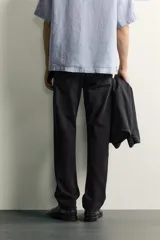 Jeans regular fit de mezclilla negra con efecto lavado, corte recto y tiro medio. Cuenta con diseño de cinco bolsillos y cierre frontal con cremallera y botón.