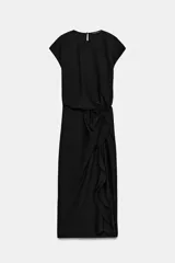 Vestido midi negro con cuello redondo y manga sisa, confeccionado por Zara Woman Collection. Presenta un diseño drapeado en la parte delantera y un bajo asimétrico con un voluminoso volante lateral. Incluye un pequeño cierre de botón en la espalda.