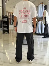 Remera oversize blanca de manga corta, con gran estampado tipográfico en color rojo en la espalda con la leyenda "The Grounded Automotive Lifestyle".