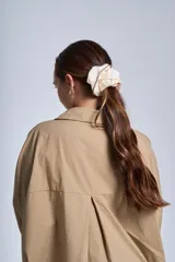 Camisa oversize color beige de manga larga con bolsillos frontales.