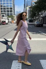 Vestido midi rosado con diseño sin mangas, cuello redondo y detalles de volados en los hombros y en el ruedo.