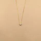Conjunto de tres collares de cadena fina tipo veneciana en plata 925 con baño de oro, cada uno con un dije de punto de luz con circonia engastada en bisel.