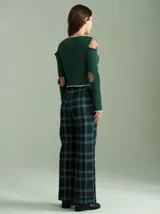 Saco de punto acanalado color bordó con detalles en color crudo en el cuello, plaqueta de botones y ruedo. Presenta aberturas en los hombros y cierre frontal con botones pequeños.