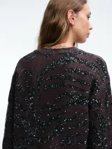 Sweater de punto con escote en V, manga larga y diseño holgado. Presenta un estampado animal print con aplicaciones de lentejuelas brillantes en tonos oscuros.